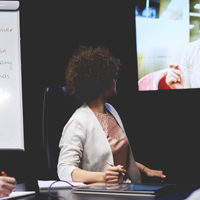 Business people communicating by television set